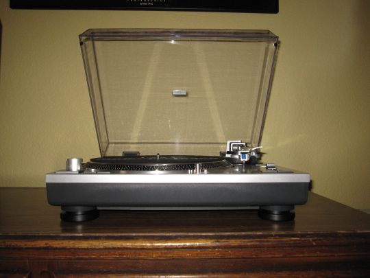 Photo shows the Audio-Technica AT-LP120-USB from the front. The platter and controls emerge from the eye-level platform.