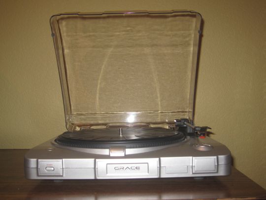 Photo shows the front side of the Grace Digital Audio Vinylwriter (AVPUSB01S) USB turntable. The dustcover is up.