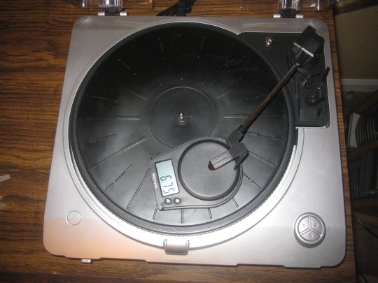 Photo shows the stylus of the Grace Digital Audio Vinylwriter (AVPUSB01S) USB turntable on a tracking force scale. The digital readout shows 6.75 grams/