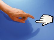 A photo of a human hand nearly touching a computer mouse pointer in the shape of a hand with its index finger extended. Reminiscent of Michelangelo's Sistine Chapel mural.