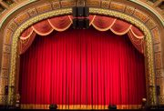 A theatre crowd anticipates the drawing of the curtain.