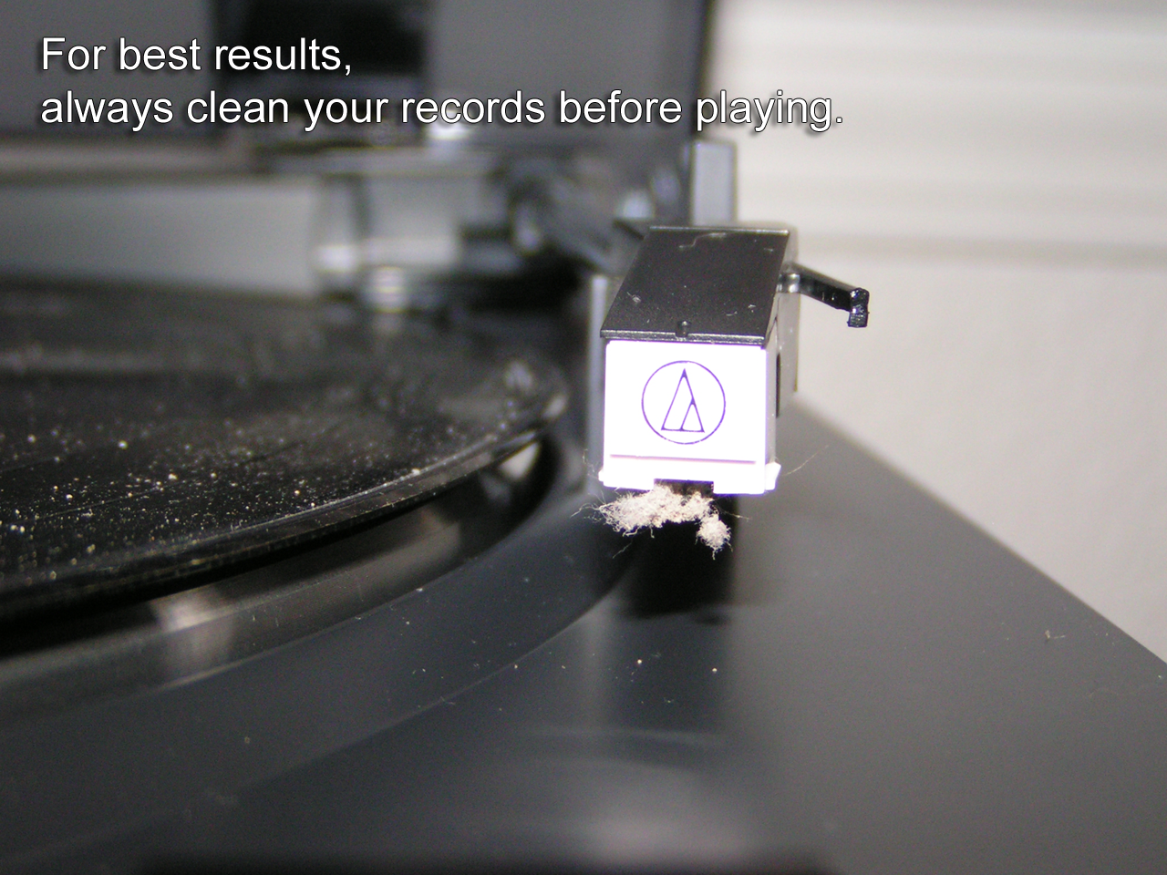 Outrageously dustry record player needle with dirty record in background. Caption reads, 'For best results, always clean your records before playing.'