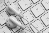 A pair of earphones atop a computer keyboard.