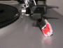 Close-up photo shows the cartridge and stylus unit laying on the plastic turntable plinth (body).